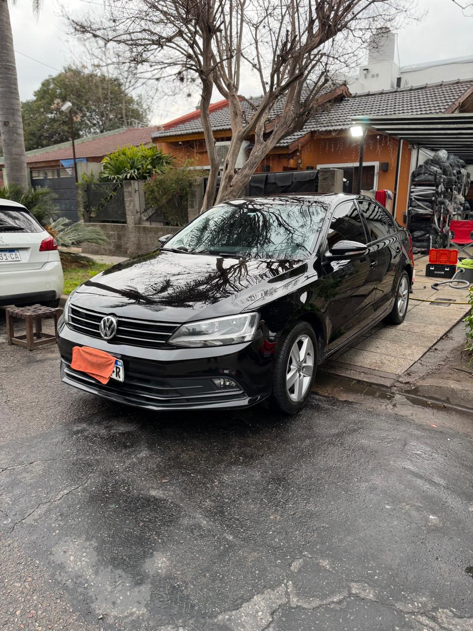 Volkswagen negro con acabado espejo después del lavado premium